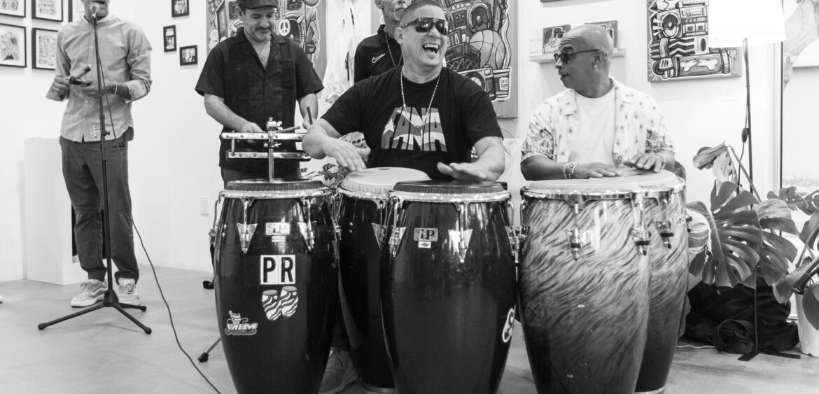 Documentary photograph from Sunset Rumba at WYN317 in Miami, showing live music and gallery activity during the closing reception for Carlos Solano’s exhibition “An Experience of Us.”