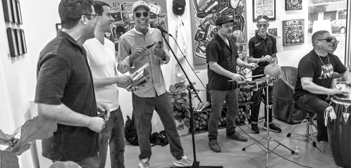 Documentary photograph from Sunset Rumba at WYN317 in Miami, showing live music and gallery activity during the closing reception for Carlos Solano’s exhibition “An Experience of Us.”