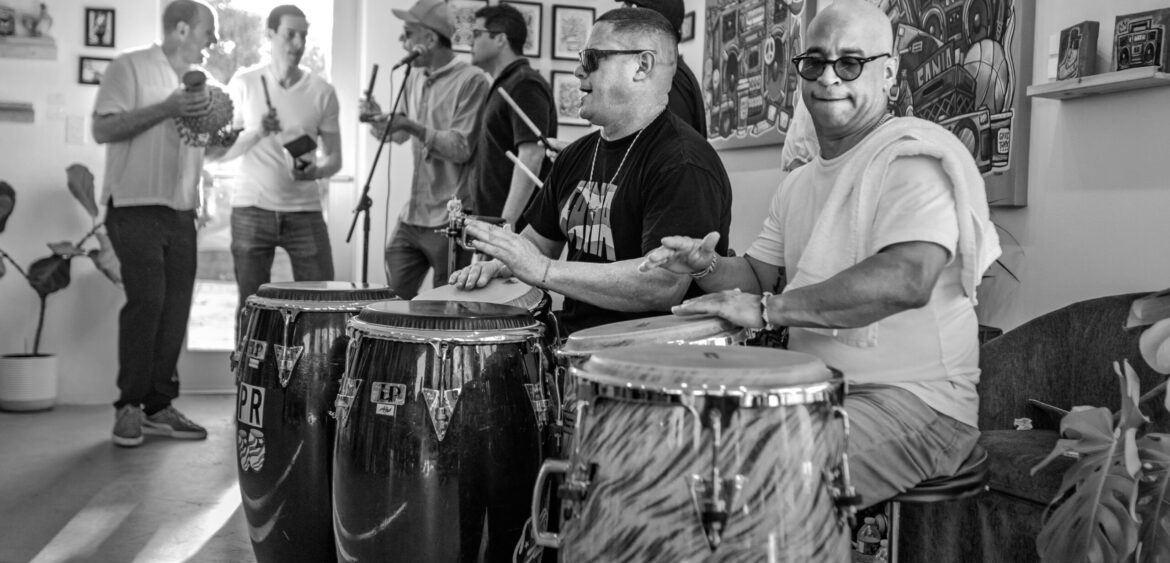 Documentary photograph from Sunset Rumba at WYN317 in Miami, showing live music and gallery activity during the closing reception for Carlos Solano’s exhibition “An Experience of Us.”